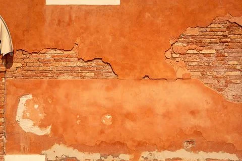 Brick orange wall with old paint cover falling off texture, Murano Venice Italy Stock Photos