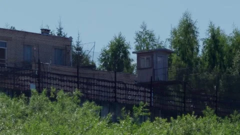 Brick prison building with guard watchtower and security fences in Daugavpils Stock Footage 340892857