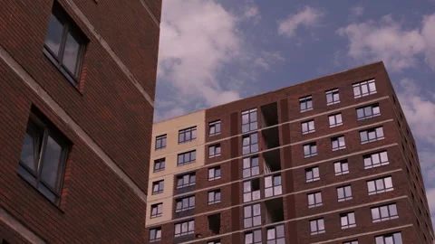 Brick residential tower with large windows against cloudy sky Video stock 343691675
