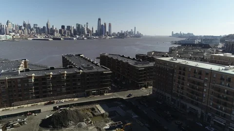 Brick riverfront housing and a construction lot in West New York Vídeos de archivo 87958057