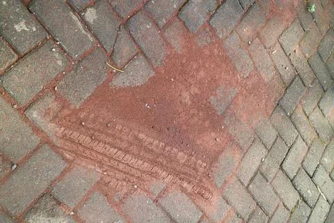 Brick sidewalk with rusty metal patch in the pavement Stock Photos