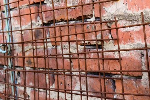 Brick siding on a wall with metal rusty grid Stock Photos