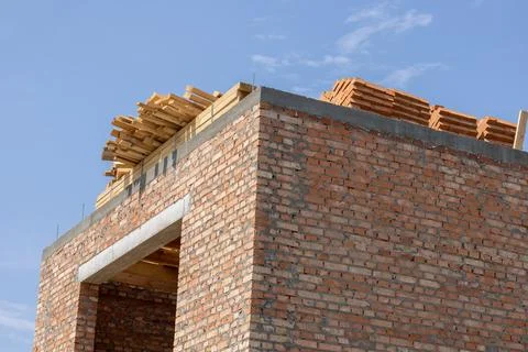 The brick structure takes shape with wooden planks neatly stacked atop, sho.. Stock Photos