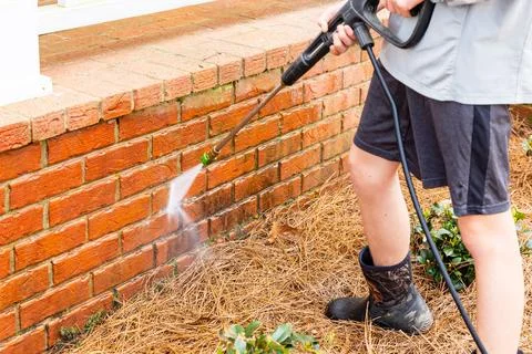 Brick surface being cleaned with water from a pressure washer. Foto stock