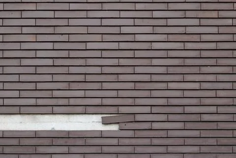 Brick texture on a wall with some falling bricks Stock Photos