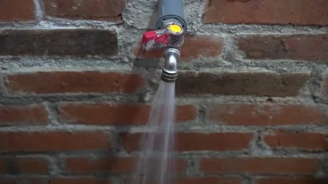 Brick urinal water flows from a faucet attached to a brick wall Stock-Footage 201744504