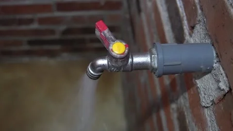 Brick urinal water flows from a faucet attached to a brick wall Stock-Footage 201746178