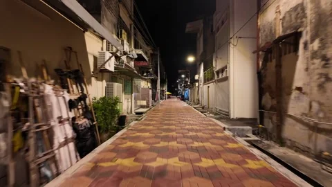 A brick walkway with a bench on the left side. The bench is empty Video stock 318264329