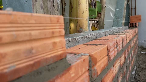 Brick wall alignment with level string at residential construction site Stock Footage 333604993