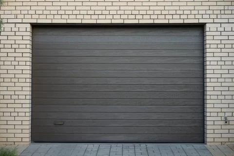 Brick wall and modern automatic garage door Stock Photos