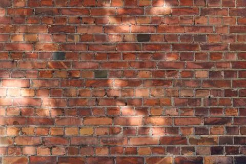 Brick wall background or texture with day light spots. Stock Photos