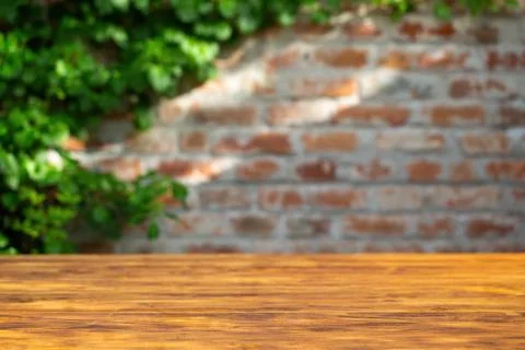 Brick wall background with wood table in front. Stock Photos