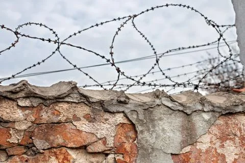 Brick wall with barbed-wire Stock Photos