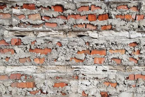Brick wall behind a layer of falling off cement or concrete Foto stock