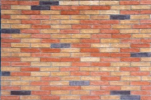 Brick wall with bricks in various colors, primarily in shades Stock Photos