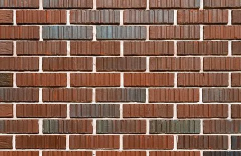 Brick wall with brown corrugated bricks with spot paint. Stock Photos