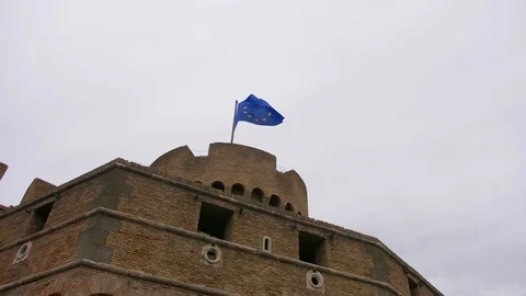 Brick wall of a castle with a waving flag of Europe. Architectural monument Stock Footage 124415689