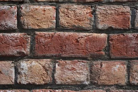 Brick wall. Close-up of hand-mixed and hand-molded bricks in a brickwork. Stock Photos