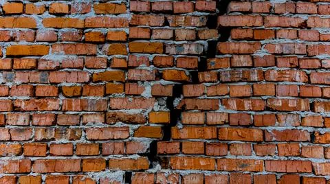 Brick wall with crack, wall background, texture. The concept of the old house Stock Photos