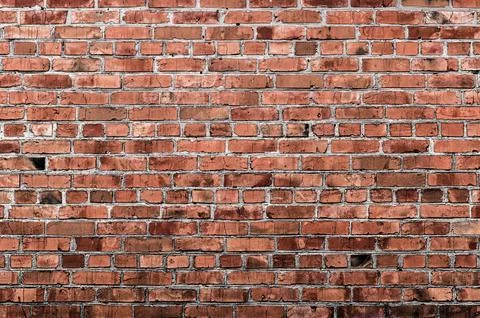 Brick wall creates abstract background with weathered textured pattern. Stock Photos