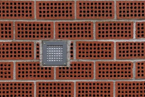 Brick wall with decorative ventilation blocks and a light fixture Stock Photos