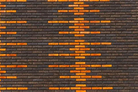 Brick wall facade with orange geometric soundwave pattern Stock Photos