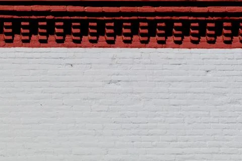 Brick wall facade with a red stripe at top Stock Photos