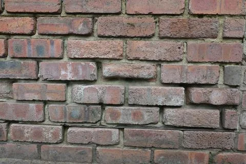 A brick wall with a few missing bricks Stock Photos