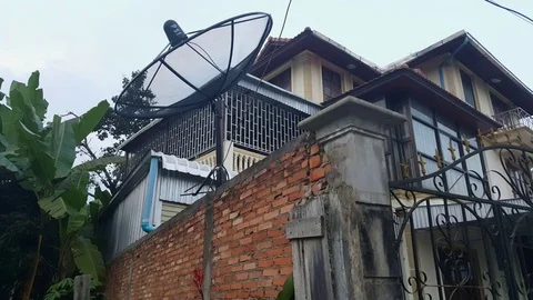 Brick wall, gate and satellite dish, private house, banana tree leaves, Sam Neua Vídeos de archivo 76794118
