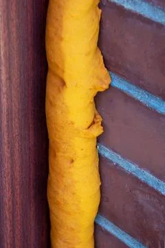 A brick wall has a piece of yellow foam attached to it Stock Photos
