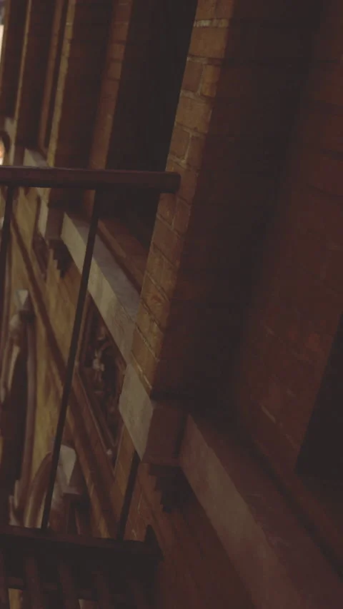 Brick wall with iron railing in urban setting at night Stock Footage 331687586