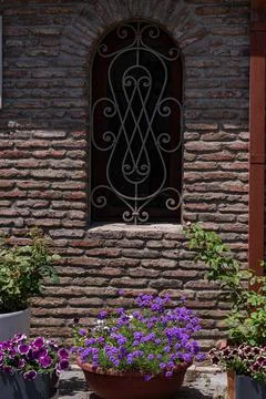 Brick wall of old house with flowers in pot Stock-Fotos