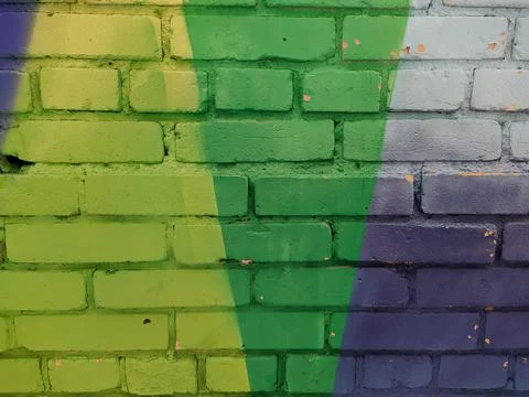 Brick wall painted in different bright colors Stock Photos