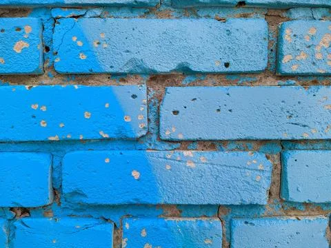 Brick wall painted in different bright colors. Stock Photos