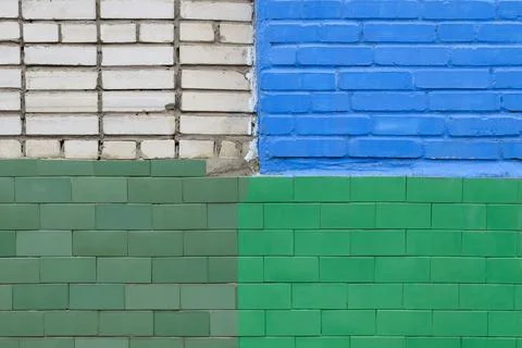 Brick wall painted in different colors by different owners Stock Photos