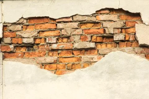 Brick wall with partially destroyed plaster, background or texture Fotos Stock
