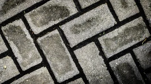 A brick wall with a pattern of black and white bricks Stock Photos