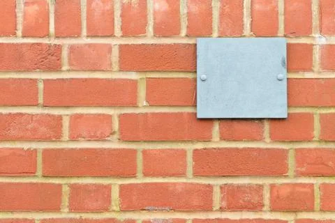 Brick wall pattern with blue metal plaque Foto stock