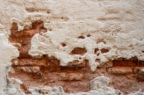 Brick wall with pieces of plaster. Wall of an old building in need of renov.. Stock Photos