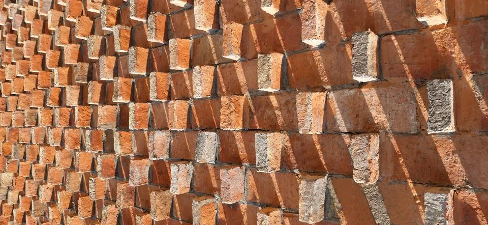 Brick wall with protruding bricks creating a geometric pattern 写真素材