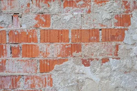 Brick wall with the rest of the plaster on an old building with a distinctive Foto stock