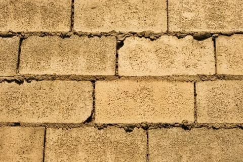 A brick wall with a rough texture and a few holes Stock Photos