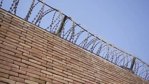 A brick wall with a security wire fence. Stock Footage 256297803