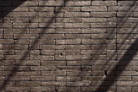 A brick wall with a shadow cast on it Stock Photos