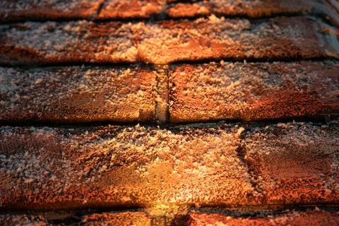 A brick wall in the snow is illuminated from below. Christmas background Stock Photos
