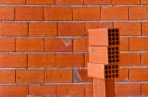Brick wall with a stack of new bricks Stock Photos