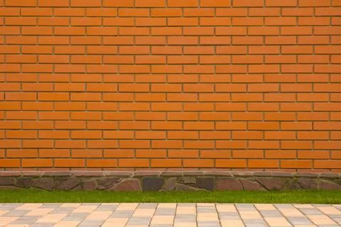 Brick wall with a stone border Brick wall with a stone border and green gr... Stock Photos