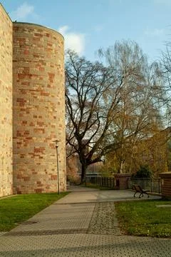 Brick Wall, Stone Path, Tall Trees and Church Tower, German Town Stock Photos