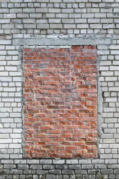 In the brick wall of white brick capped with red brick window. Stock Photos