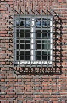 Brick wall with window guard Stock Photos